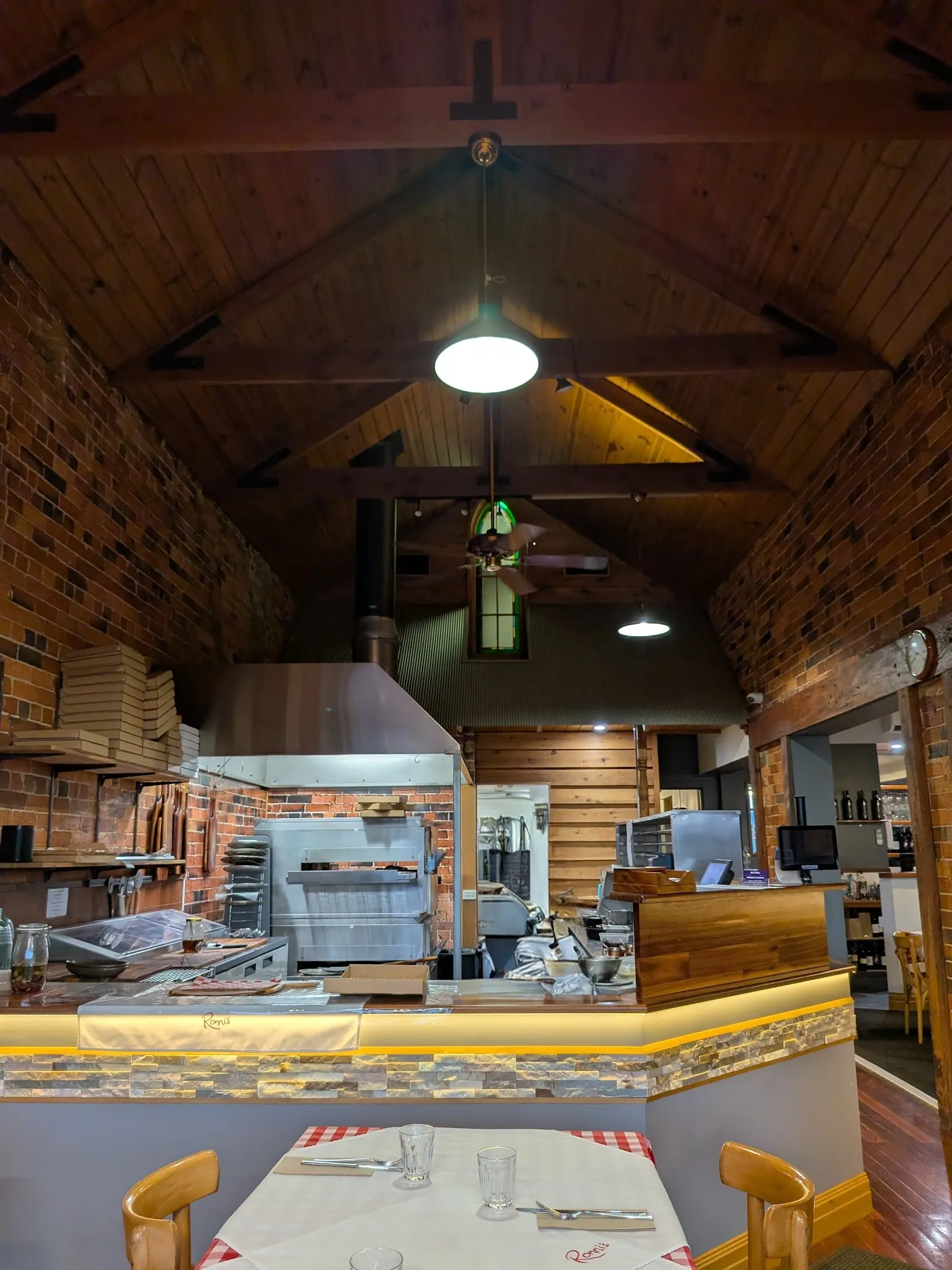 Ronni's kitchen pass with vaulted timber ceiling and terracotta brick walls
